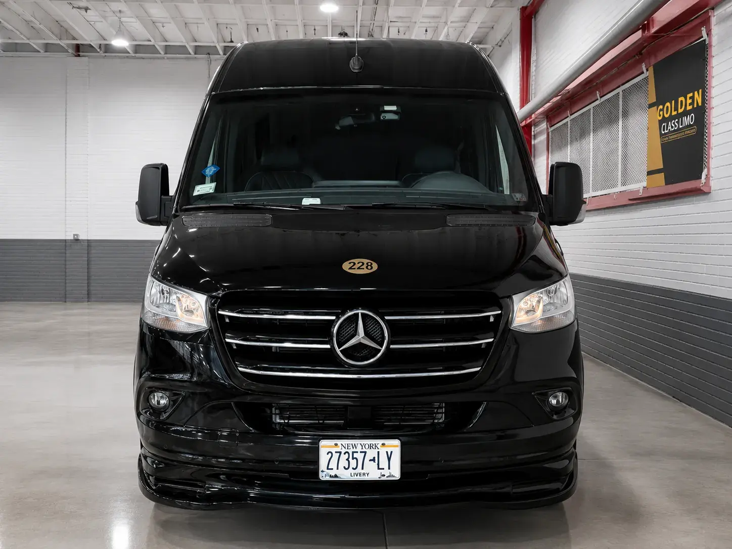 Black Mercedes Sprinter photographed head-on in the Golden Class Limo garage