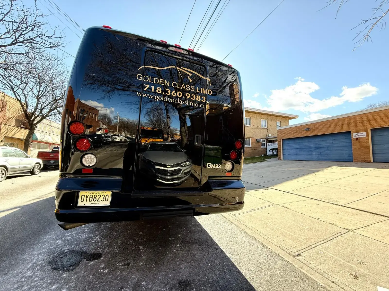 Rear of the 29-passenger mini bus in Golden Class Limo livery with its phone number