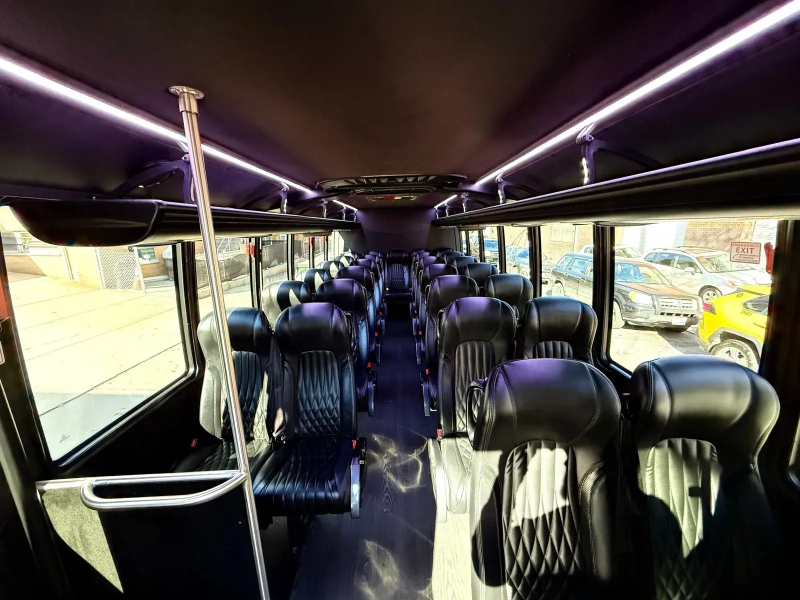 Inside the 29-passenger mini bus, quilted leather seats under violet ambient lighting