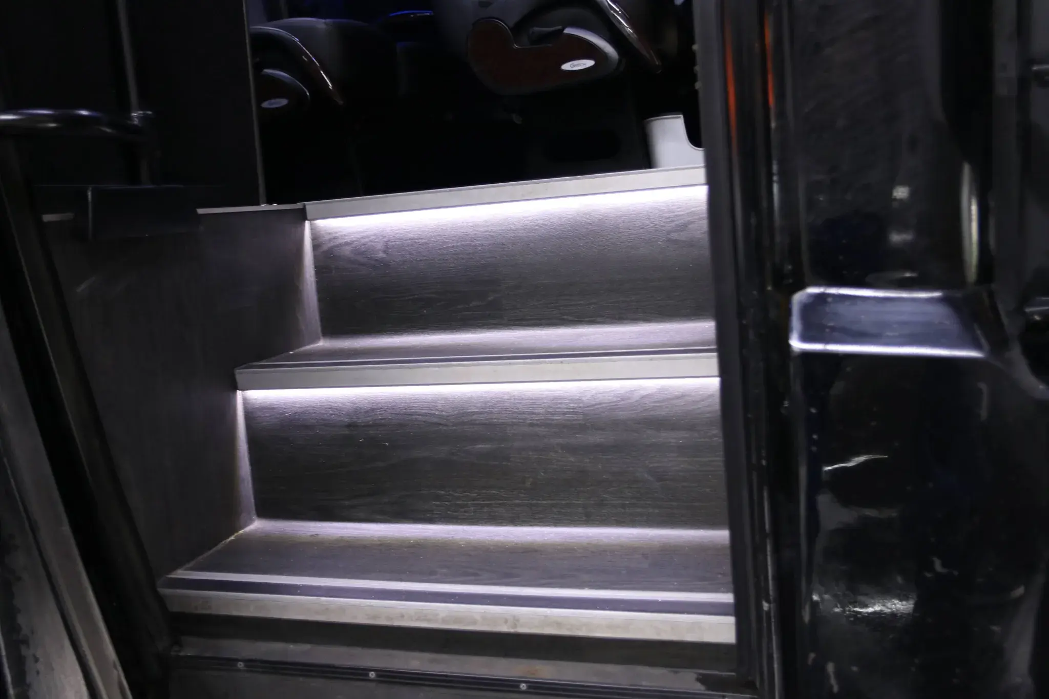 Entry steps of the mini bus lit by their ambient strip lighting