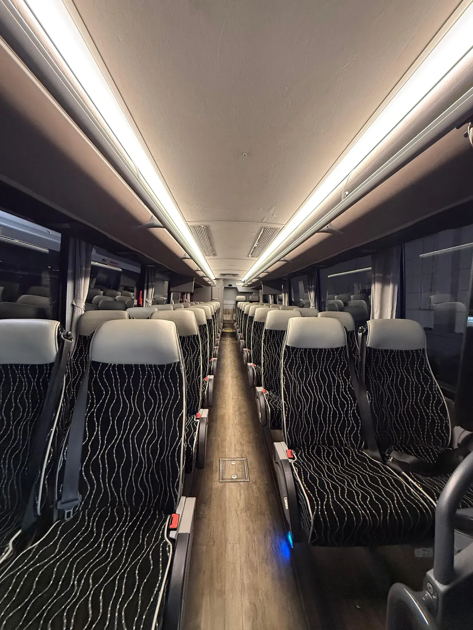 Rows of patterned reclining coach seats running the length of the cabin