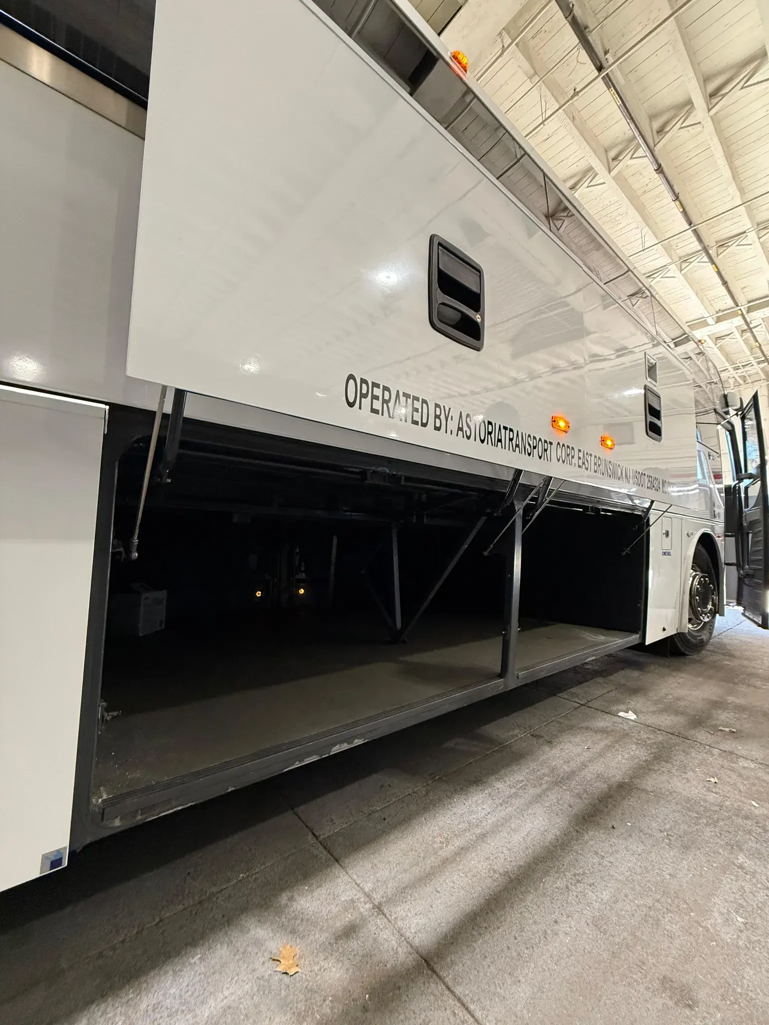 Underfloor luggage bays open along the side of the charter coach