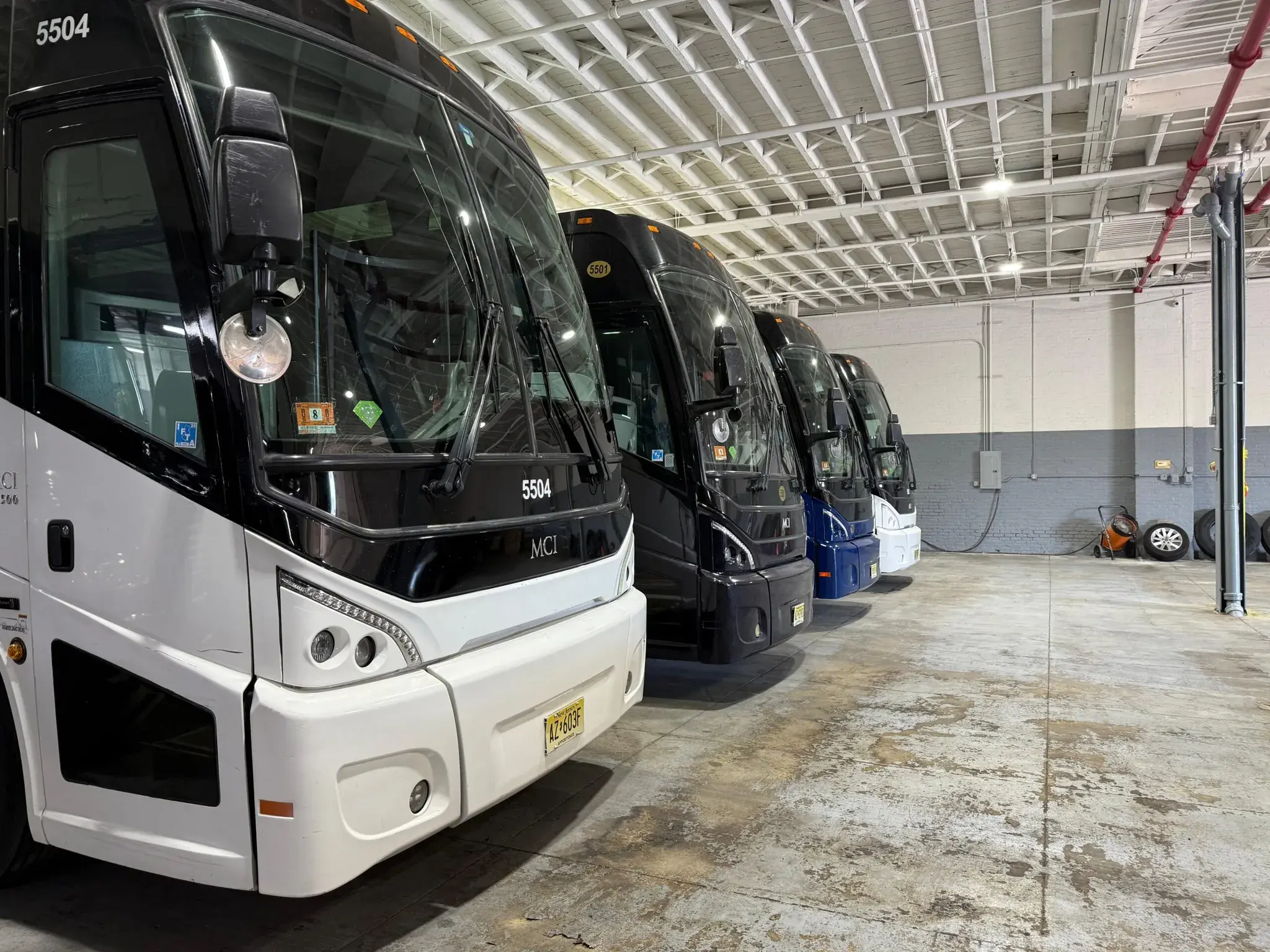 A row of MCI motor coaches lined up inside the garage