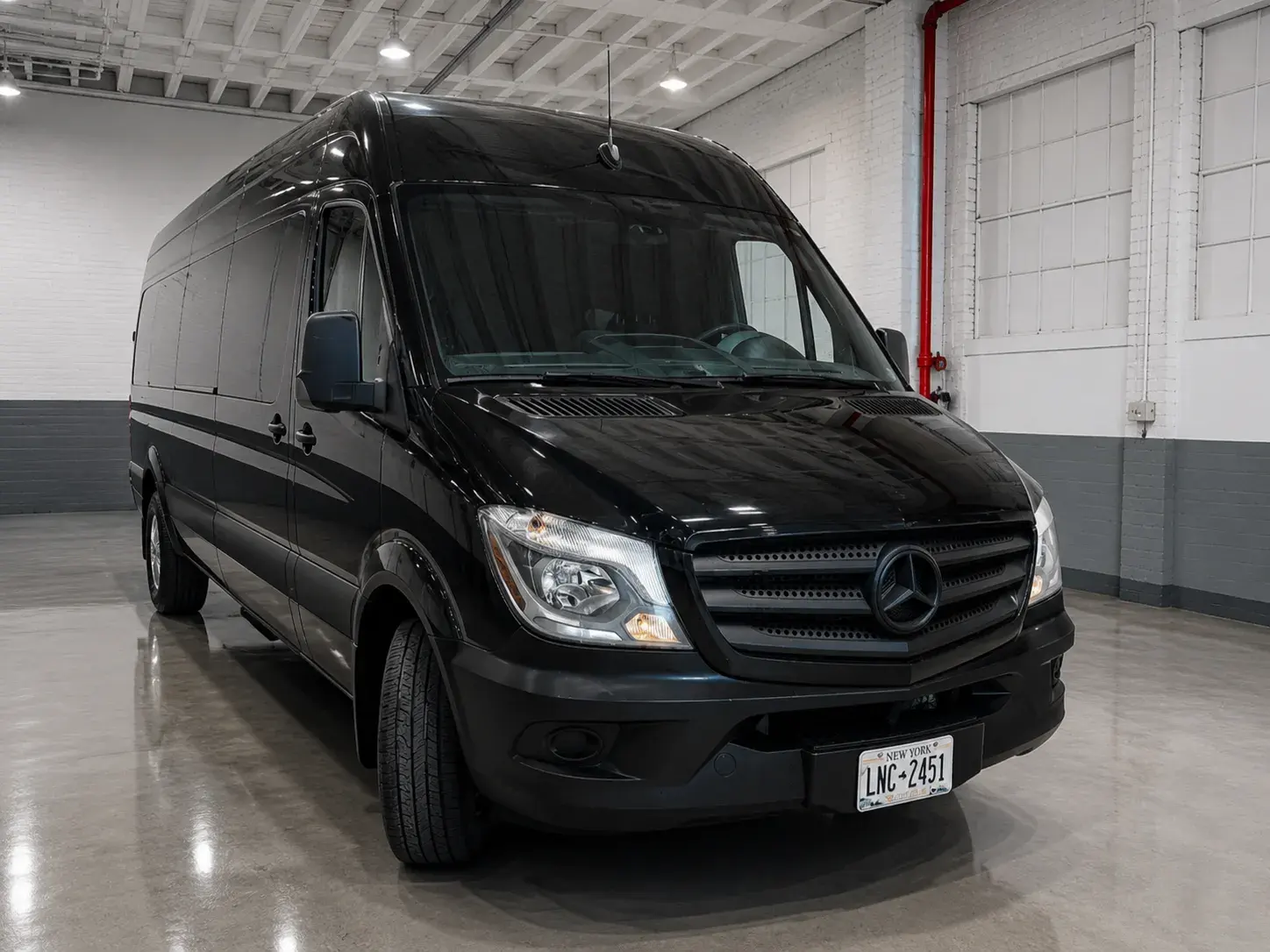 Black Mercedes Sprinter cargo van photographed in the Golden Class Limo warehouse, panel sides with no rear glass, New York plate LNC-2451
