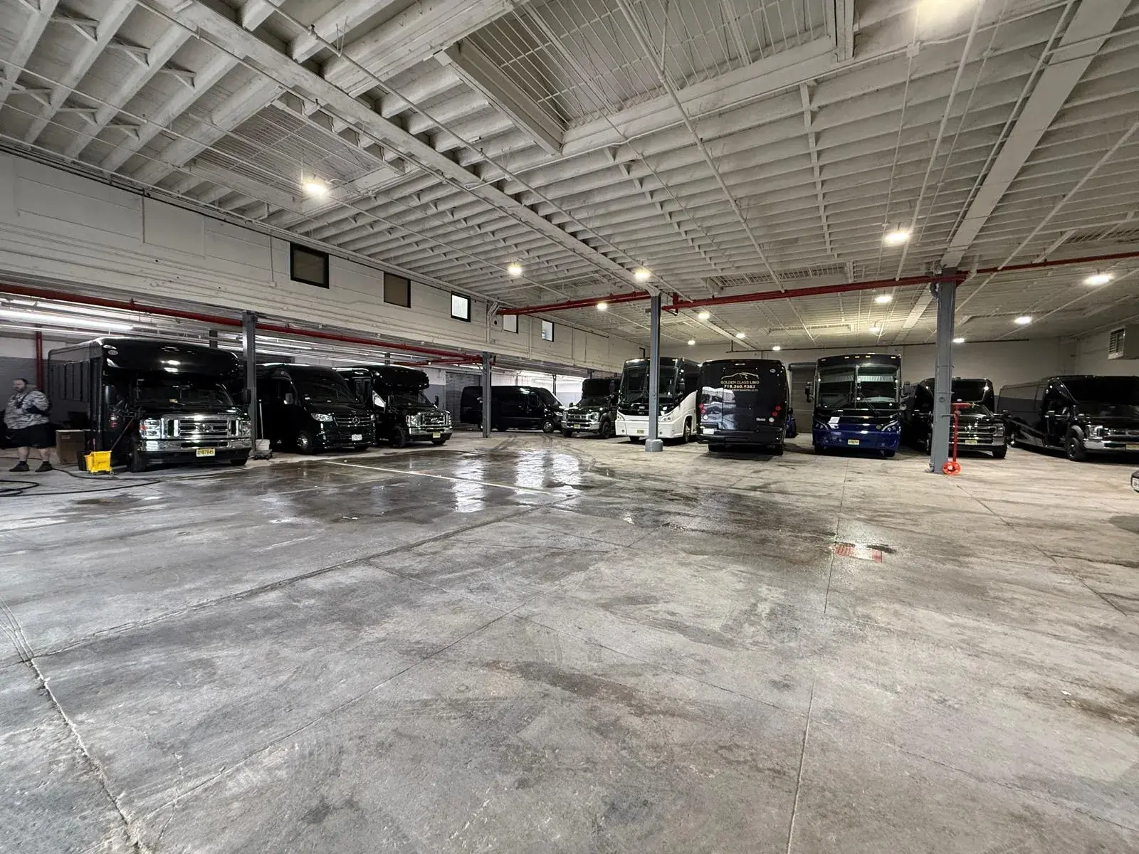 Mini buses, Sprinter vans and coaches parked side by side inside the Golden Class Limo garage