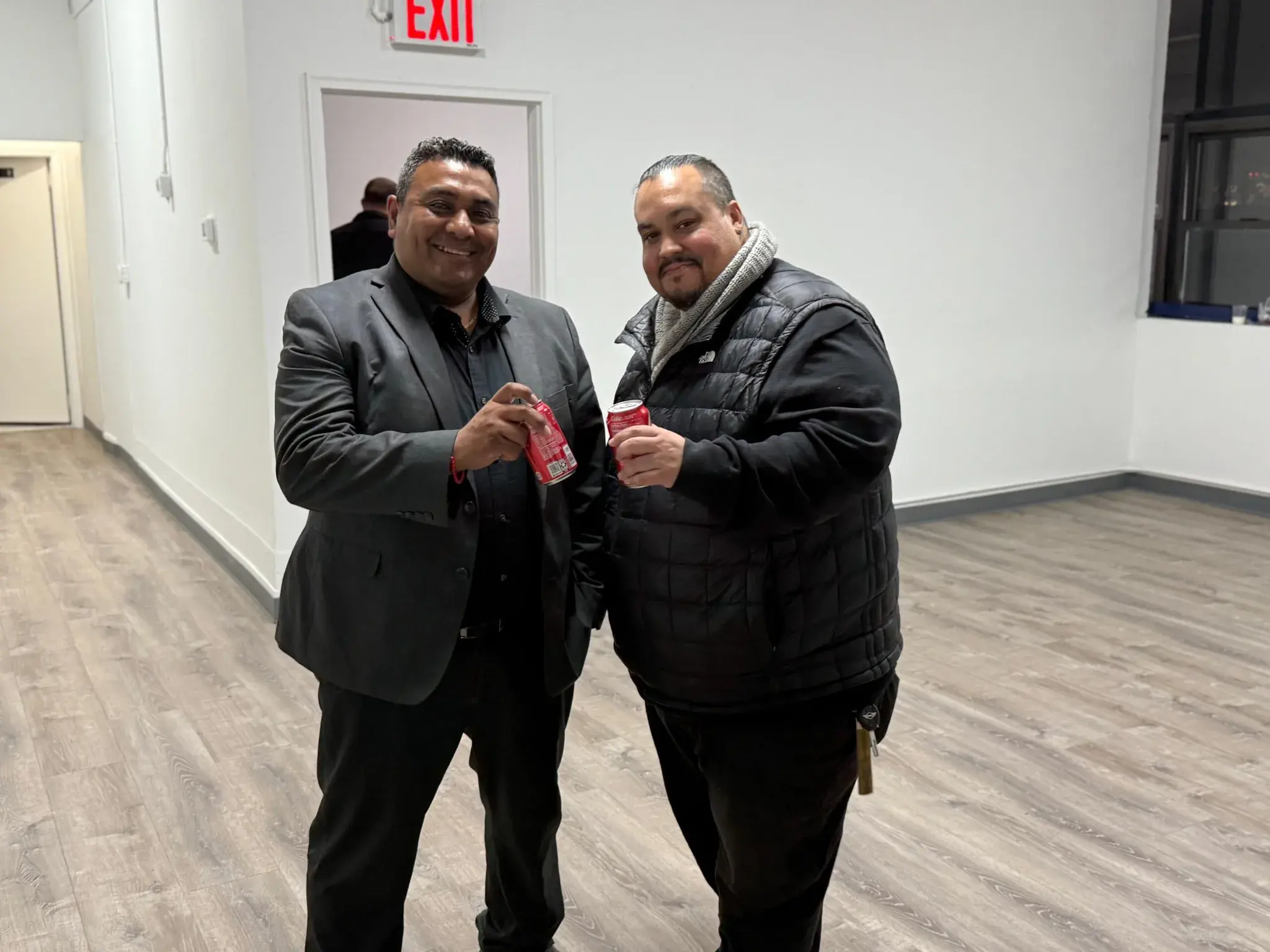 Two Golden Class Limo colleagues raising drinks and smiling at the office celebration