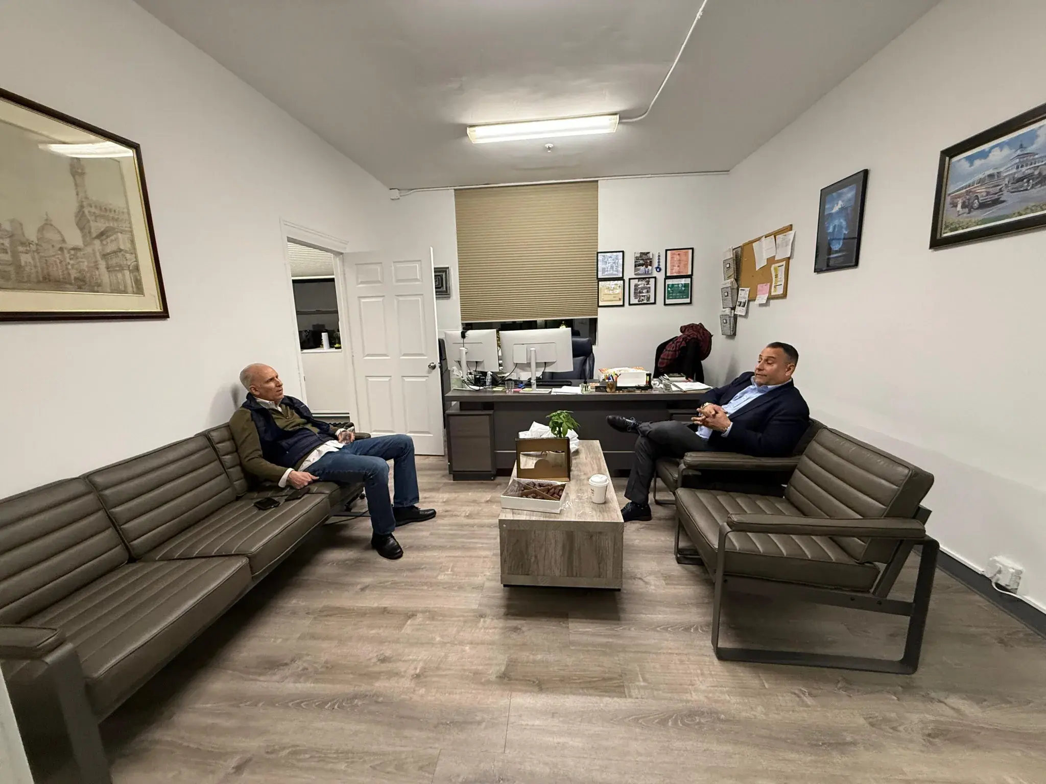 Two colleagues sitting in the office lounge with a tray of dates on the table between them