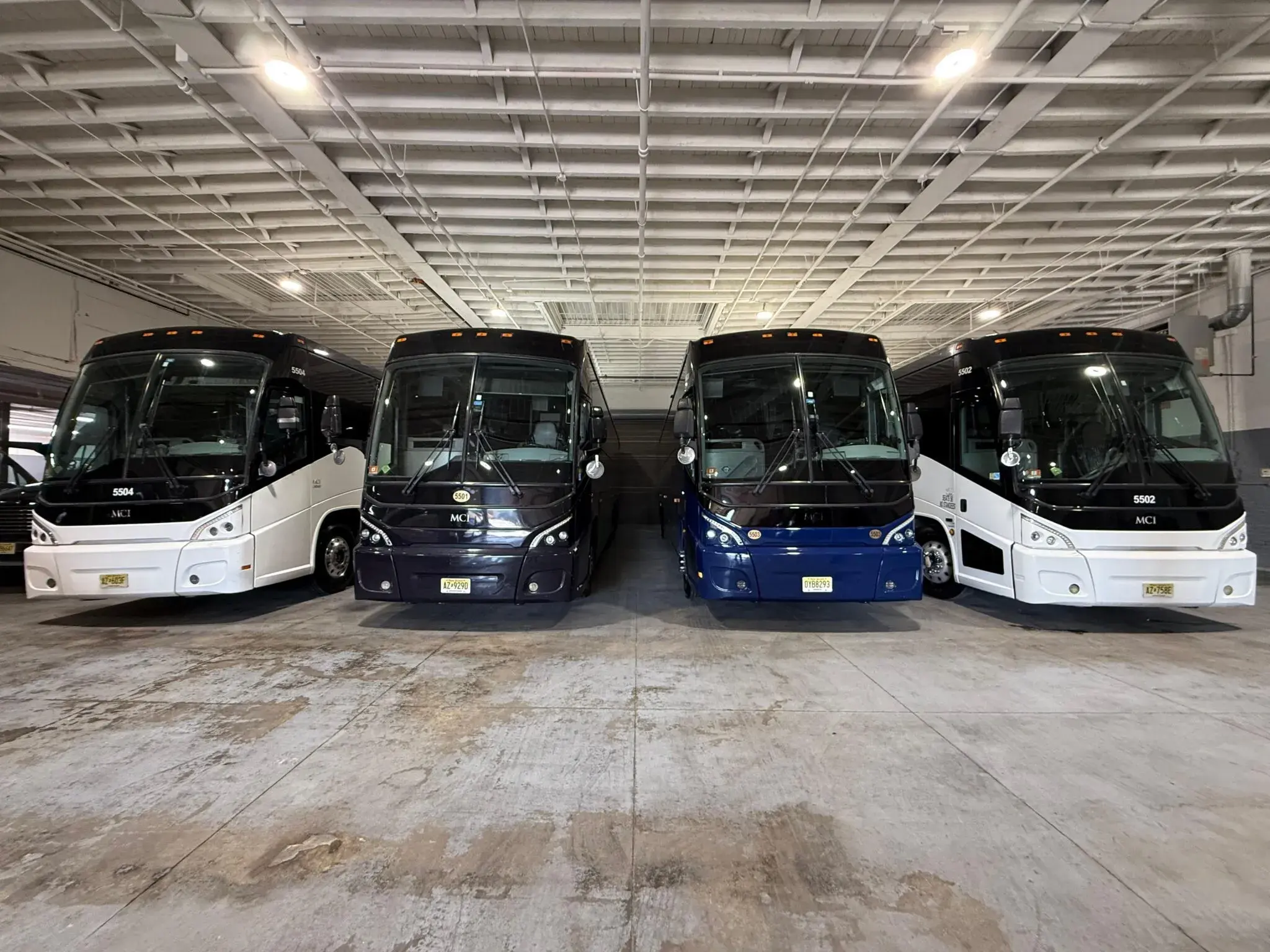 Four MCI motor coaches parked head-on in the operator’s depot